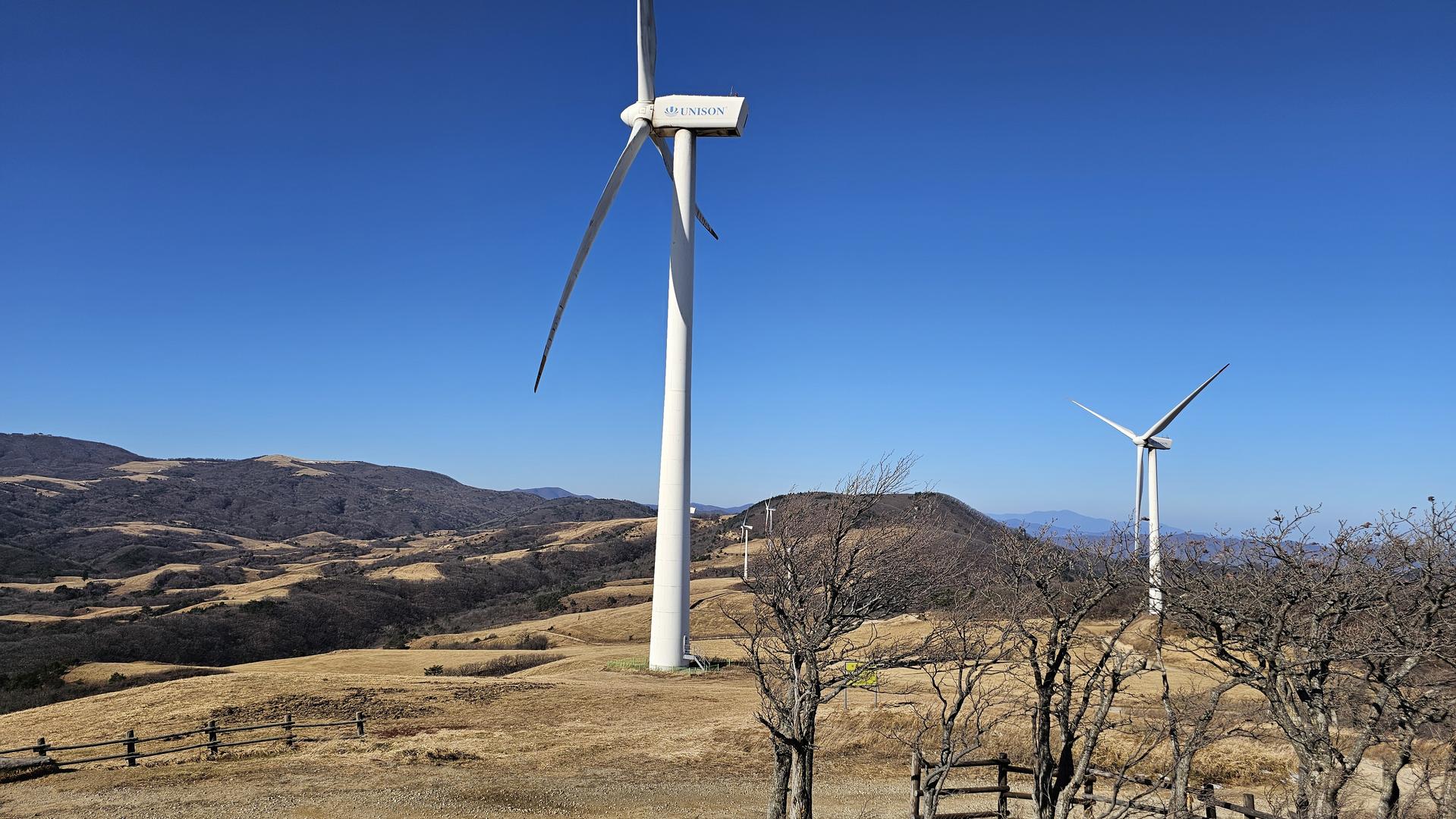 푸른 하늘 아래 대관령 언덕에 서 있는 거대한 풍력발전기들