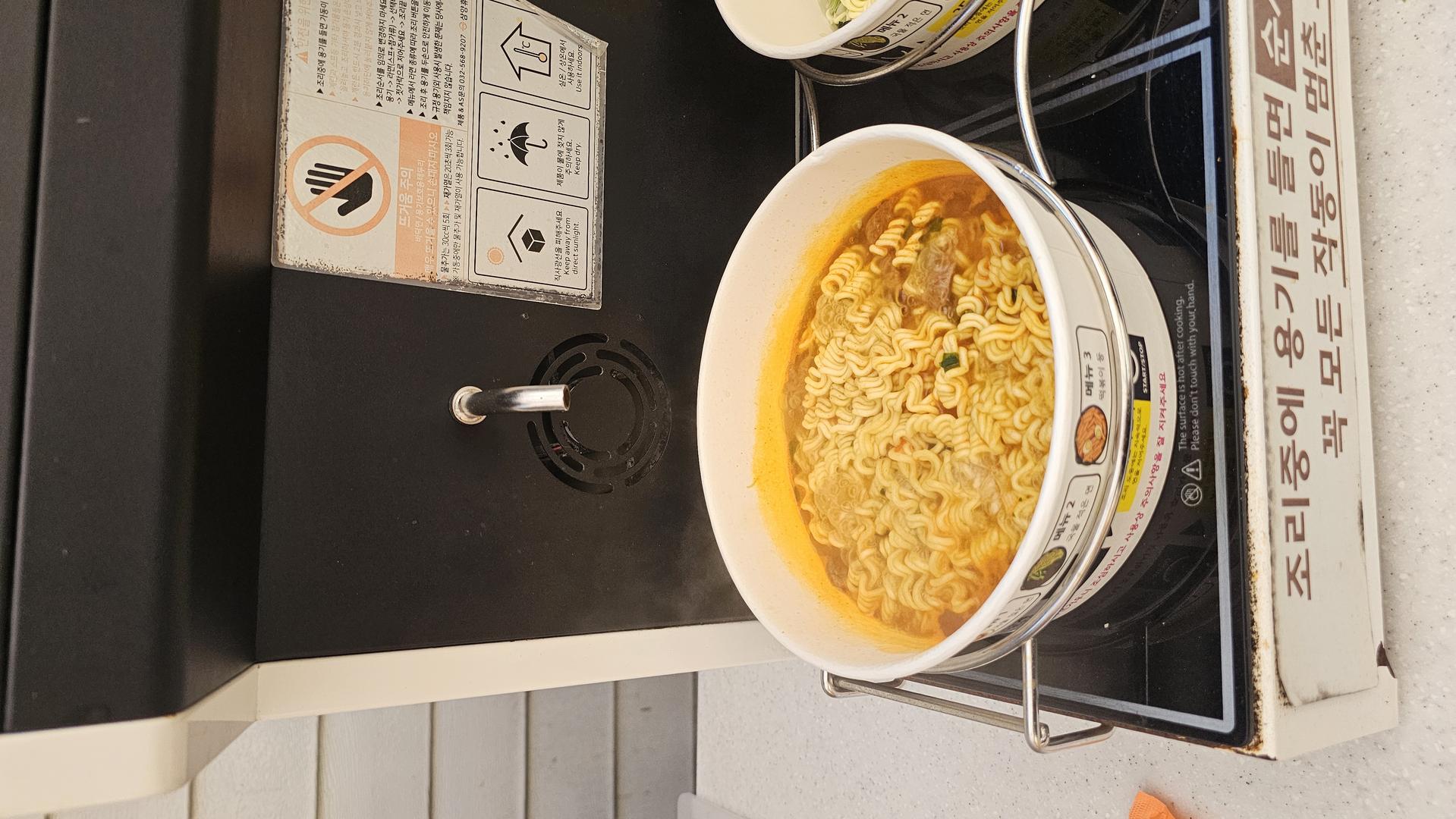 즉석 라면 조리기에서 맛있게 익어가는 꼬들꼬들한 라면의 클로즈업 샷