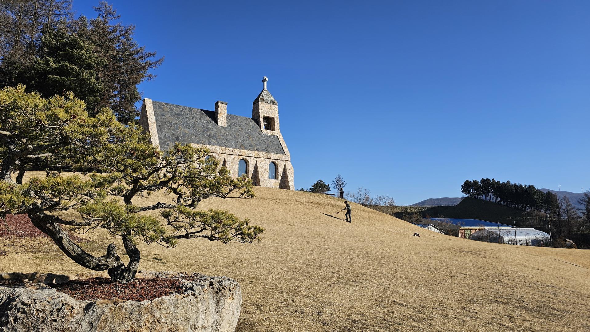 겨울 잔디 언덕 위에 서 있는 이천 에덴파라다이스 호텔 그레이스 채플의 외부 모습